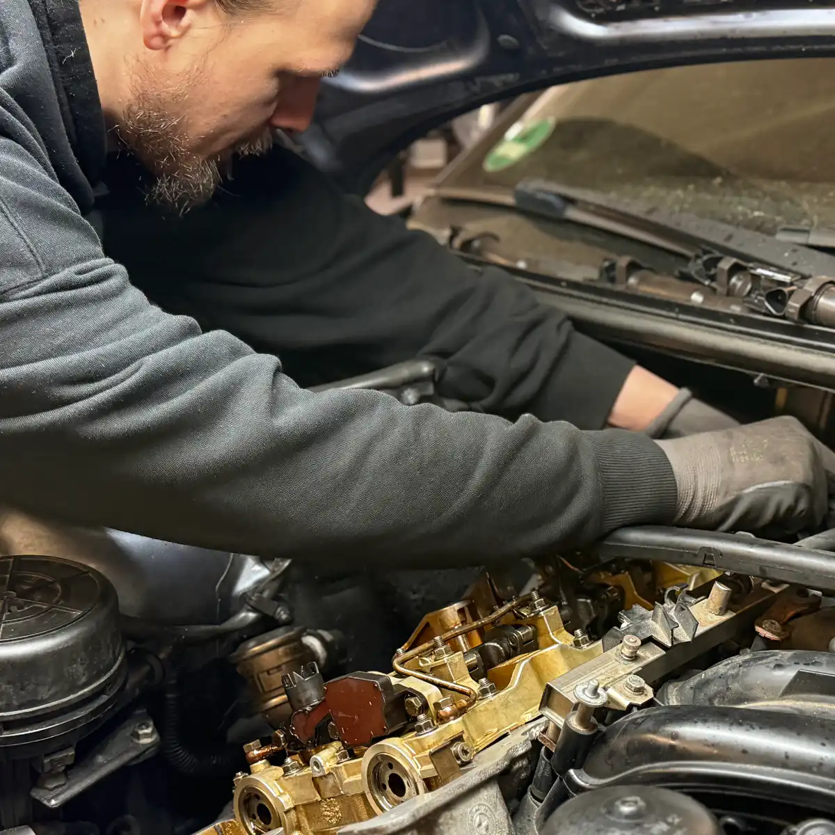 Mechaniker repariert Motorteile im Auto.